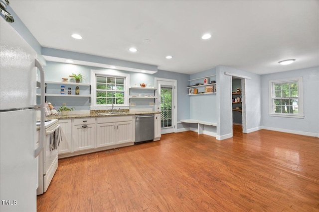 1013 Oak Forest Dr NW, Wilson, NC 27896 - kitchen featuring open shelves, white appliances, light wood-type flooring, light stone counters, and white cabinets
