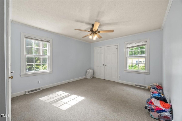 1013 Oak Forest Dr NW, Wilson, NC 27896 - unfurnished bedroom with crown molding, carpet, a textured ceiling, a closet, and a ceiling fan