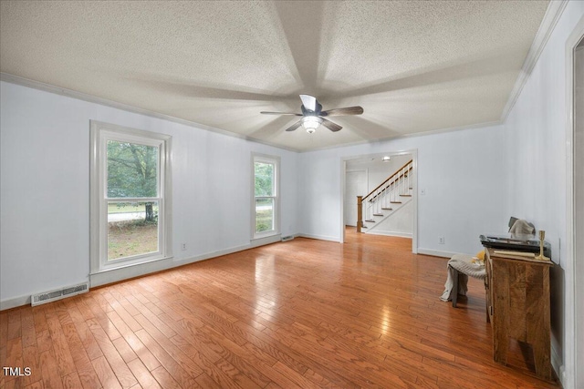 1013 Oak Forest Dr NW, Wilson, NC 27896 - unfurnished room featuring crown molding, stairway, a textured ceiling, ceiling fan, and hardwood / wood-style floors