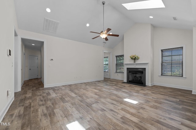 801 Socata Ln, Mebane, NC 27302 - unfurnished living room with a fireplace, a skylight, high vaulted ceiling, wood finished floors, and a ceiling fan