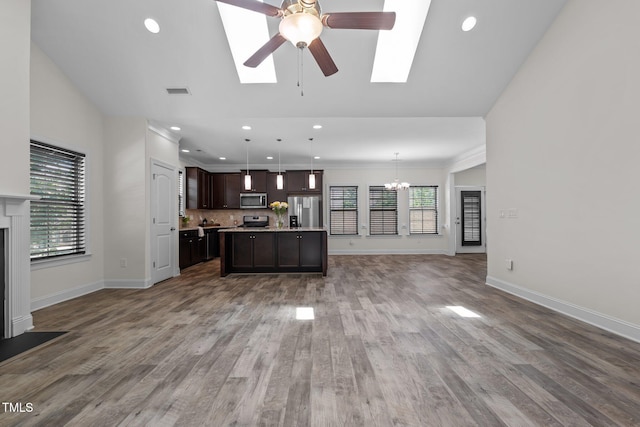 801 Socata Ln, Mebane, NC 27302 - unfurnished living room featuring a chandelier, a fireplace, a skylight, plenty of natural light, and recessed lighting
