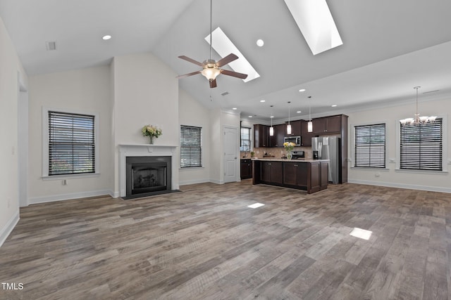 801 Socata Ln, Mebane, NC 27302 - unfurnished living room with a chandelier, a fireplace with flush hearth, high vaulted ceiling, light wood-type flooring, and a ceiling fan