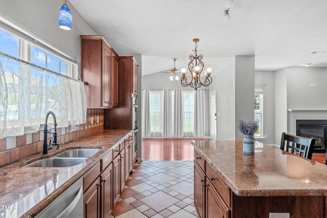 760 Stackhurst Way, Wake Forest, NC 27587 - kitchen featuring stainless steel appliances, pendant lighting, light stone counters, a kitchen island, and brown cabinets