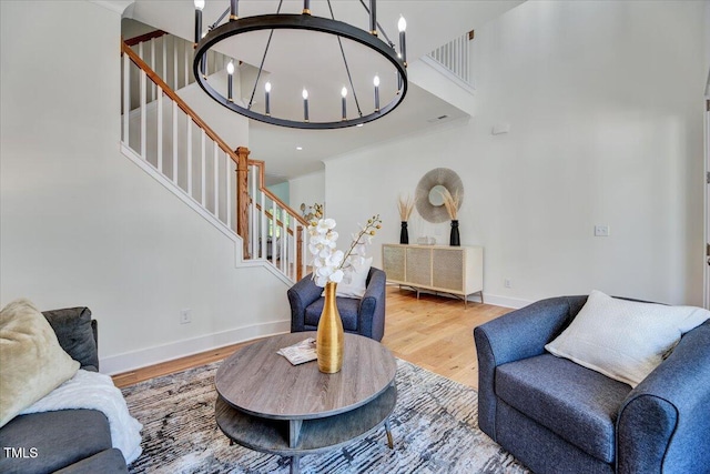 8011 Old Trail Dr, Durham, NC 27712 - living room with stairway, a chandelier, wood finished floors, baseboards, and a towering ceiling