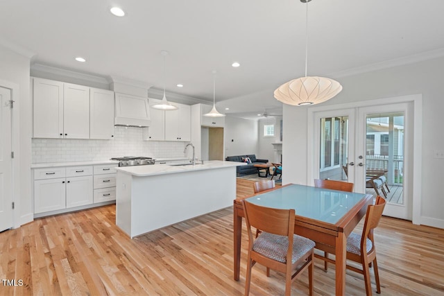 414 Wyndham Dr, Chapel Hill, NC 27516 - kitchen with french doors, ornamental molding, light wood-style flooring, backsplash, and light countertops
