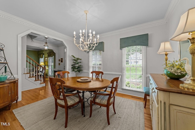 8004 Gabriels Bend Dr, Raleigh, NC 27612 - dining room with stairway, light wood-style floors, a chandelier, and ornamental molding