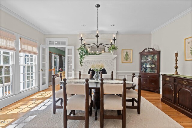 8004 Gabriels Bend Dr, Raleigh, NC 27612 - dining space with ornamental molding, a chandelier, french doors, and light wood-style flooring