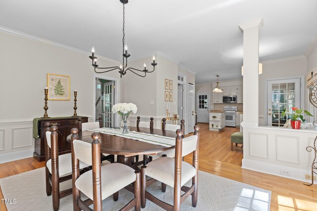 8004 Gabriels Bend Dr, Raleigh, NC 27612 - dining space with light wood-style floors, crown molding, a chandelier, and a wainscoted wall