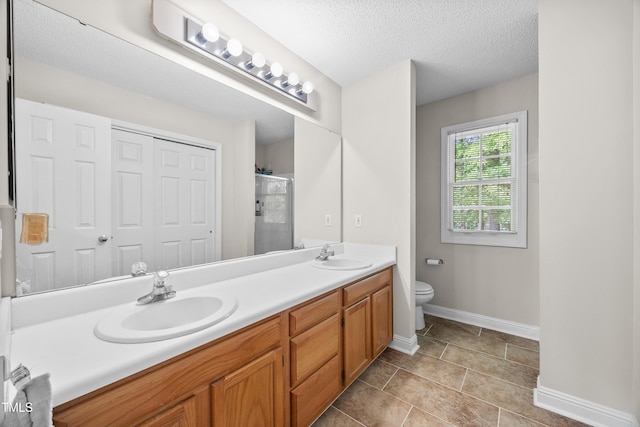 304 Gold Point Dr, Cary, NC 27519 - bathroom with double vanity, a stall shower, and a textured ceiling