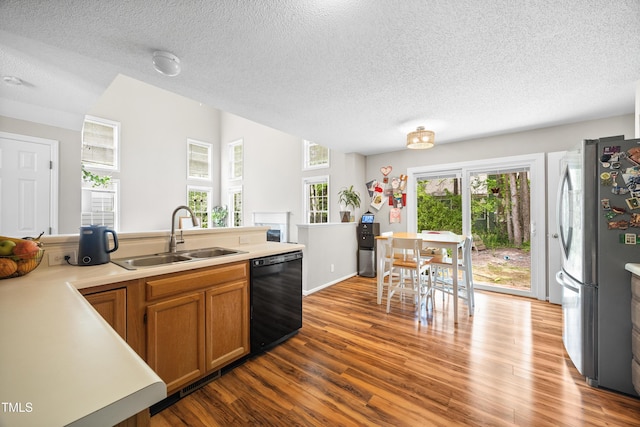 304 Gold Point Dr, Cary, NC 27519 - kitchen featuring dishwasher, freestanding refrigerator, wood finished floors, a textured ceiling, and brown cabinets
