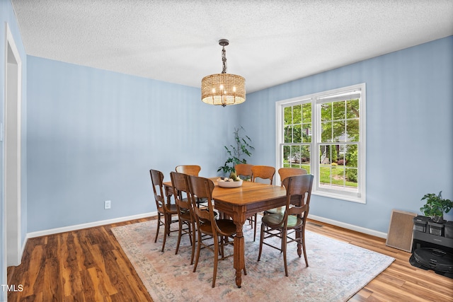 304 Gold Point Dr, Cary, NC 27519 - dining space featuring a chandelier, wood finished floors, and a textured ceiling