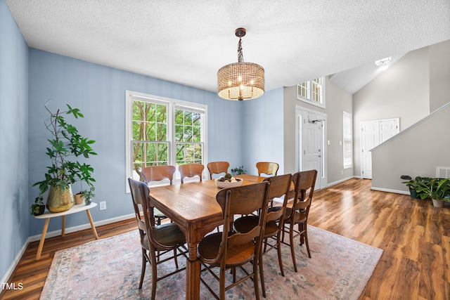 304 Gold Point Dr, Cary, NC 27519 - dining space featuring a textured ceiling, wood finished floors, a chandelier, and vaulted ceiling