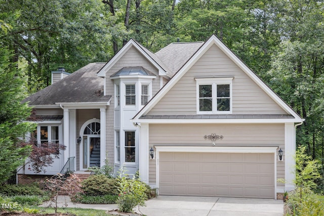 105 Gorge Ct, Cary, NC 27518 - view of front of property featuring driveway, a garage, a chimney, roof with shingles, and view of wooded area