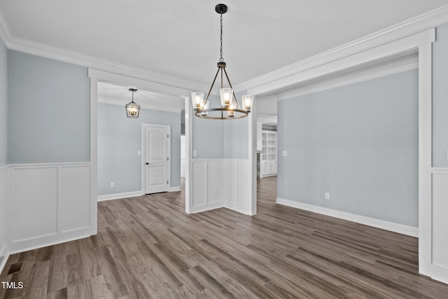 2237 Heartland Rd, Battleboro, NC 27809 - unfurnished dining area with a chandelier, dark wood-style floors, a wainscoted wall, crown molding, and a decorative wall