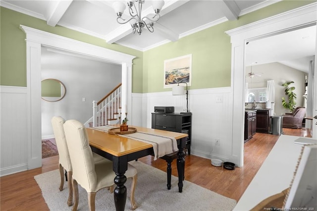 951 Whispering Pines Dr, Spring Lake, NC 28390 - dining area featuring light wood finished floors, beam ceiling, wainscoting, a chandelier, and stairway