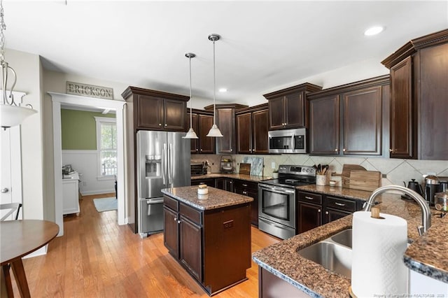 951 Whispering Pines Dr, Spring Lake, NC 28390 - kitchen with appliances with stainless steel finishes, a sink, dark brown cabinets, dark stone countertops, and a kitchen island