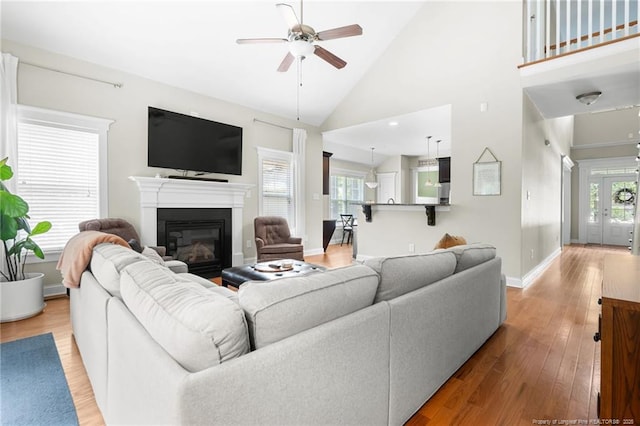 951 Whispering Pines Dr, Spring Lake, NC 28390 - living room featuring a ceiling fan, a glass covered fireplace, wood finished floors, baseboards, and high vaulted ceiling