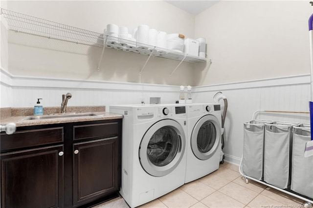 951 Whispering Pines Dr, Spring Lake, NC 28390 - laundry area with washing machine and dryer, a wainscoted wall, light tile patterned flooring, and cabinet space