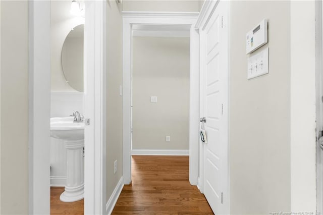 951 Whispering Pines Dr, Spring Lake, NC 28390 - hallway with wood finished floors, baseboards, and a sink