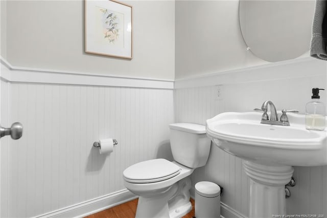 951 Whispering Pines Dr, Spring Lake, NC 28390 - half bath with toilet, wood finished floors, wainscoting, and a sink