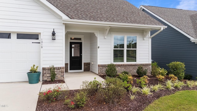 1319 Richfield Oaks Dr, Fuquay Varina, NC 27526 - property entrance featuring an attached garage, roof with shingles, brick siding, and concrete driveway