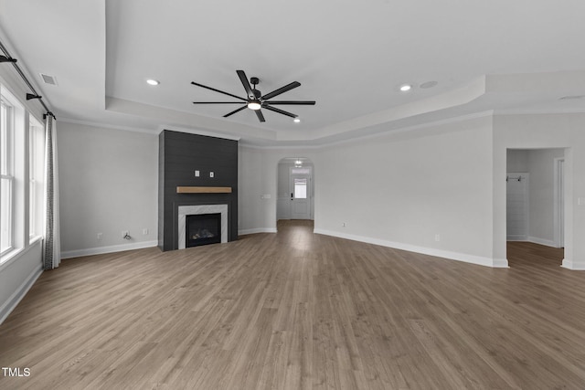 1319 Richfield Oaks Dr, Fuquay Varina, NC 27526 - unfurnished living room featuring a tray ceiling, ceiling fan, arched walkways, recessed lighting, and wood finished floors