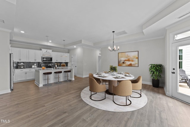 1319 Richfield Oaks Dr, Fuquay Varina, NC 27526 - dining space with a tray ceiling, a chandelier, light wood finished floors, and recessed lighting