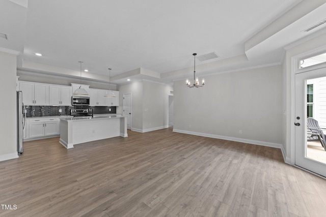 1319 Richfield Oaks Dr, Fuquay Varina, NC 27526 - kitchen with stainless steel appliances, a tray ceiling, a chandelier, open floor plan, and recessed lighting