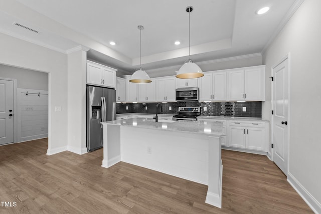 1319 Richfield Oaks Dr, Fuquay Varina, NC 27526 - kitchen with stainless steel appliances, backsplash, white cabinets, a tray ceiling, and wood finished floors