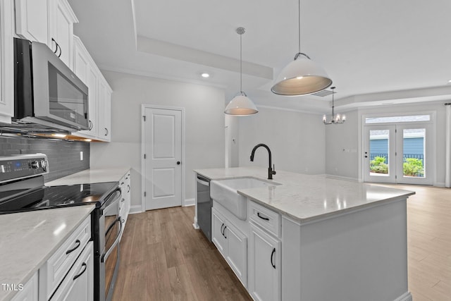 1319 Richfield Oaks Dr, Fuquay Varina, NC 27526 - kitchen with stainless steel appliances, a tray ceiling, backsplash, wood finished floors, and white cabinets
