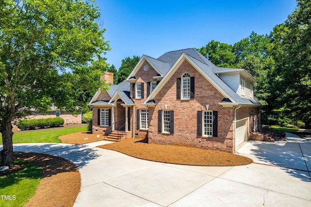 619 Baybush Dr, Raleigh, NC 27615 - colonial house with concrete driveway, brick siding, a chimney, and an attached garage