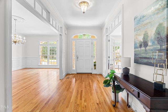 619 Baybush Dr, Raleigh, NC 27615 - foyer with a chandelier, light wood finished floors, and crown molding