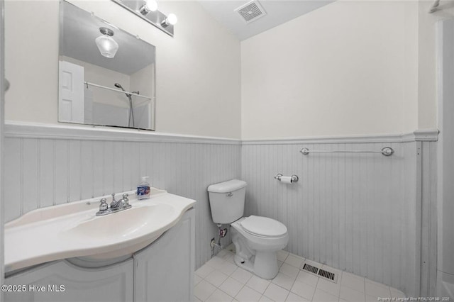 240 Eppingdale Dr, Spring Lake, NC 28390 - bathroom featuring a wainscoted wall, toilet, vanity, tile patterned floors, and a shower