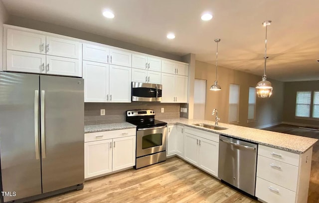 18 Danbury Ct, Pittsboro, NC 27312 - kitchen with appliances with stainless steel finishes, a sink, a peninsula, light wood-type flooring, and recessed lighting