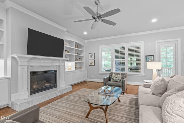 2121 Vecchio Ln, Apex, NC 27502 - living room featuring wood finished floors, ceiling fan, a high end fireplace, crown molding, and recessed lighting