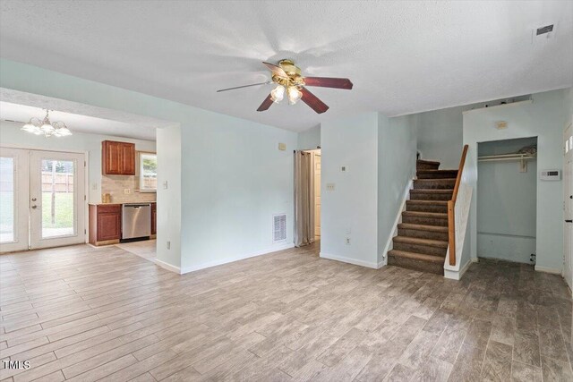 4709 Tyne Dr, Durham, NC 27703 - unfurnished living room featuring stairway, ceiling fan, light wood finished floors, a chandelier, and a textured ceiling