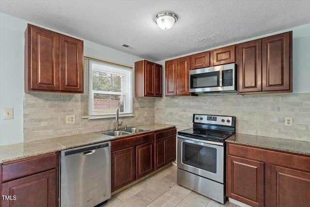 4709 Tyne Dr, Durham, NC 27703 - kitchen featuring stainless steel appliances, backsplash, a textured ceiling, and light tile patterned flooring