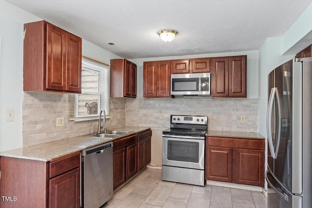 4709 Tyne Dr, Durham, NC 27703 - kitchen featuring stainless steel appliances, light tile patterned floors, backsplash, light stone countertops, and a textured ceiling
