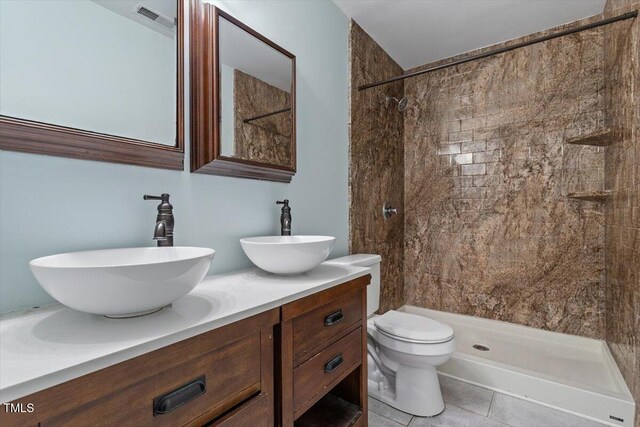 4709 Tyne Dr, Durham, NC 27703 - full bath with double vanity, a tile shower, and tile patterned floors