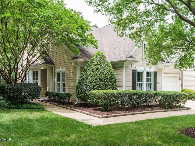 101 Lake Tillery Dr, Cary, NC 27519 - view of property hidden behind natural elements with an attached garage, roof with shingles, and a front lawn