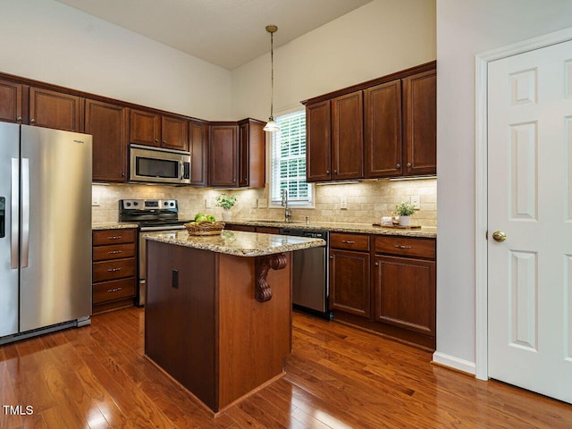 101 Lake Tillery Dr, Cary, NC 27519 - kitchen with stainless steel appliances, dark wood-style flooring, a center island, and backsplash