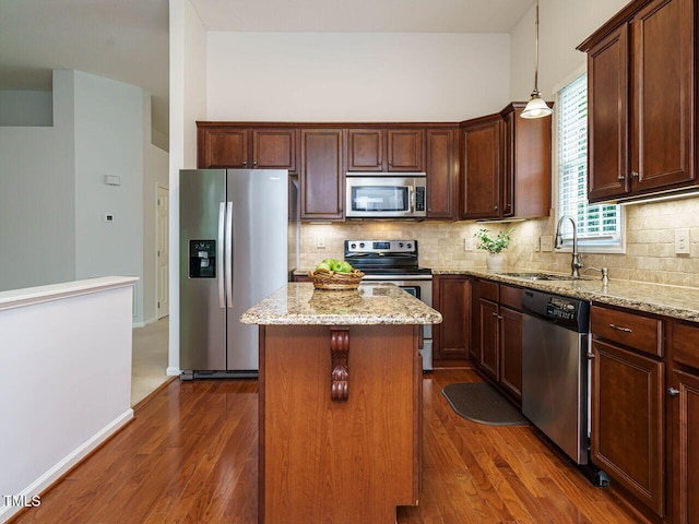 101 Lake Tillery Dr, Cary, NC 27519 - kitchen featuring appliances with stainless steel finishes, a kitchen island, dark wood-style flooring, and light stone counters