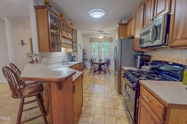 734 Crystal Forest Dr, Semora, NC 27343 - kitchen featuring stainless steel microwave, black gas stove, brown cabinetry, and decorative backsplash