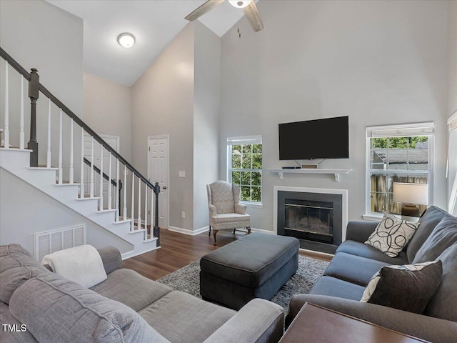 221 Antique Lace Way, Holly Springs, NC 27540 - living area featuring high vaulted ceiling, wood finished floors, stairs, a ceiling fan, and a glass covered fireplace