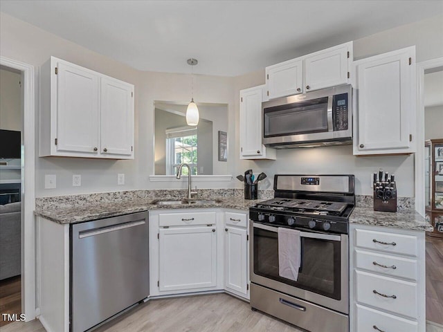 221 Antique Lace Way, Holly Springs, NC 27540 - kitchen with appliances with stainless steel finishes, white cabinetry, light wood-style floors, and light stone counters
