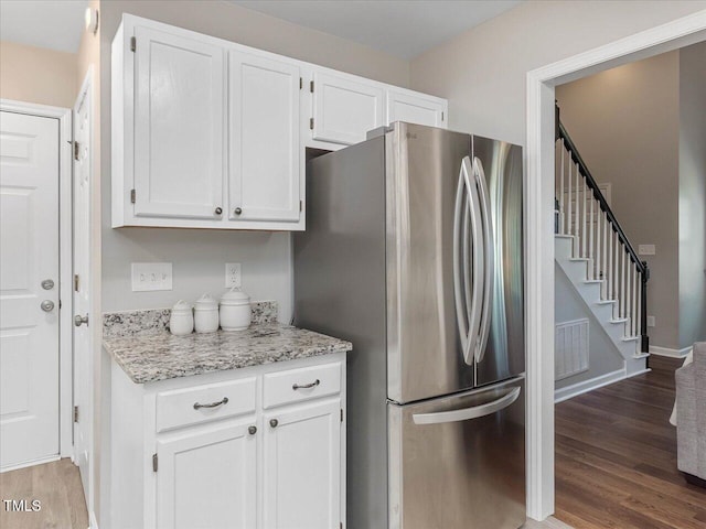 221 Antique Lace Way, Holly Springs, NC 27540 - kitchen with freestanding refrigerator, wood finished floors, white cabinets, and light stone countertops