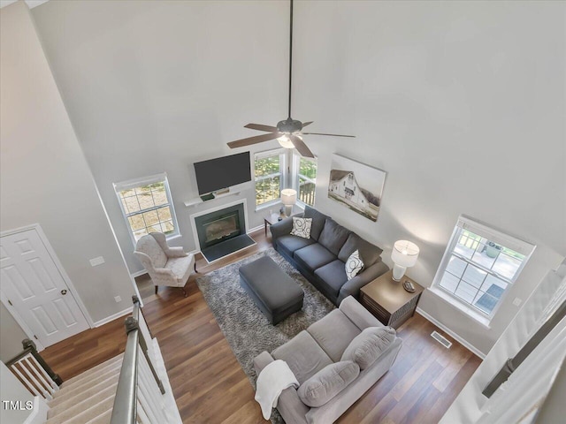 221 Antique Lace Way, Holly Springs, NC 27540 - living area featuring a high ceiling, wood finished floors, a fireplace with flush hearth, and a ceiling fan
