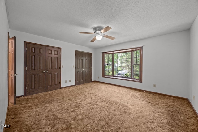 2382 Council Rd, Graham, NC 27253 - unfurnished bedroom featuring multiple closets, carpet floors, a textured ceiling, and ceiling fan