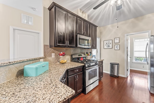 100 Beaconwood Ln, Holly Springs, NC 27540 - kitchen with appliances with stainless steel finishes, a ceiling fan, dark brown cabinets, light stone countertops, and tasteful backsplash