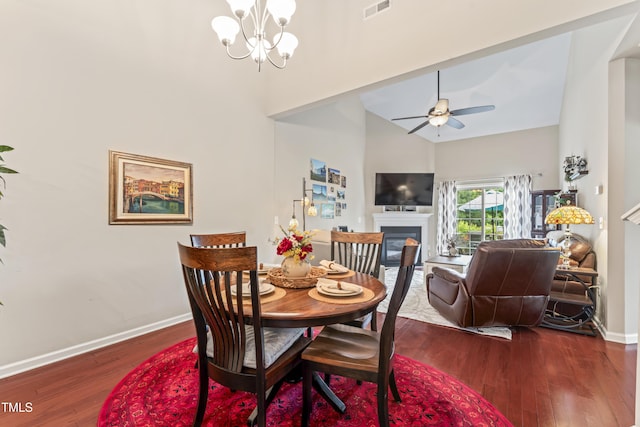 100 Beaconwood Ln, Holly Springs, NC 27540 - dining space with a towering ceiling, a glass covered fireplace, dark wood finished floors, a chandelier, and ceiling fan
